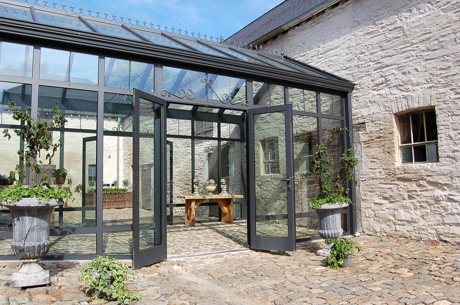 Open black aluminium French doors that are part of a larget grey conservatory